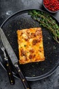 Lasagna with mince beef meat and tomato bolognese sauce on a plate. Black background. Top view Royalty Free Stock Photo