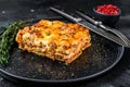 Lasagna with mince beef meat and tomato bolognese sauce on a plate. Black background. Top view Royalty Free Stock Photo