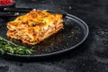 Lasagna with mince beef meat and tomato bolognese sauce on a plate. Black background. Top view. Copy space Royalty Free Stock Photo