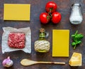 Lasagna, tomatoes, minced meat and other ingredients. Dark background. Italian cuisine