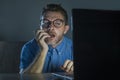 Lascivious aroused addict man in nerd glasses watching sex movie online late night at laptop computer looking pervert and Royalty Free Stock Photo