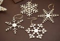 Laser Cut Wood Snowflakes Ornaments. Wooden Snowflakes on Brown Background. Christmas Holliday Concept.