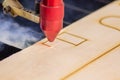 Laser engraver working and engraving wooden board with smoke Royalty Free Stock Photo