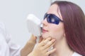 Laser hair removal on the face, above the upper lip. removal of the antennae of the girl