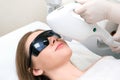 Laser hair removal of the mustache and chin of a young beautiful woman. Depilation on the face. Device for laser