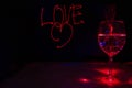 Laser light painting of Love sign for valentines day in a dark background with sparkling  wine glass for the celebration Royalty Free Stock Photo