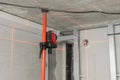 Laser measurement during renovation. Construction tools and equipment. Red laser light lines for level measure.
