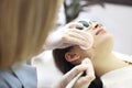 Laser mole removal on a woman`s cheek in a beauty salon