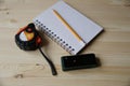 Laser range finder, tape measure, notebook, pencil on a light background Royalty Free Stock Photo