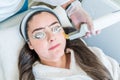 Laser skin treatment using the Excel V laser by Cutera. Cutera logo shows. Patient is wearing laser light protective goggles. Lase