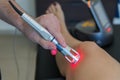 Laser therapy on a knee used to treat pain.