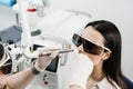 Laser treatment of chronic rhinitis. ENT doctor with laser treats girl patient in protective glasses. Laser treatment Royalty Free Stock Photo