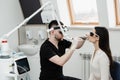Laser treatment of chronic rhinitis. ENT doctor with laser treats girl patient in protective glasses. Laser treatment Royalty Free Stock Photo