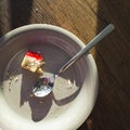 Last bite of strawberry jam cheesecake and used spoon on white plate Royalty Free Stock Photo