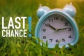 Last Chance, Business Concept - text showing Last Chance with a clock on grass Royalty Free Stock Photo