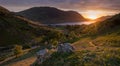 Last of the evening sun shining across valley in the Lake District with shadows and sunset sky