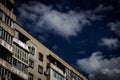 The last floors of a brick multi-story building against the background of a blue sky with white clouds Royalty Free Stock Photo