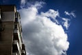 The last floors of a brick multi-story building against the background of a blue sky with white clouds Royalty Free Stock Photo