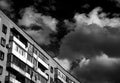 The last floors of a brick multi-story building against the background of a blue sky with white clouds Royalty Free Stock Photo