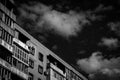 The last floors of a brick multi-story building against the background of a blue sky with white clouds Royalty Free Stock Photo