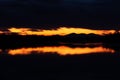 Last light in sky above mountain silhouette framed with dark clouds at twilight