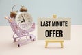 Last Minute Offer text message for promotion with alarm clock and shopping trolley cart on pink and blue background Royalty Free Stock Photo