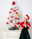Last minute till midnight. New year countdown. Girl kid santa hat costume with clock counting time to new year. How much
