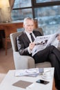 Earnest senior businessman reviewing news