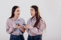 That last news is unbelievable. Two sisters twins standing and posing in the studio with white background Royalty Free Stock Photo