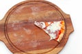 Last one slice of delicious Italian pizza with ham and cheese on wooden board on white table. Pizza time. Top view. Close-up Royalty Free Stock Photo