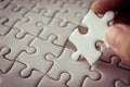 Last piece of white plain jigsaw holding by hand Royalty Free Stock Photo