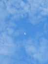 Last Quarter moon surrounded by puffy white clouds Royalty Free Stock Photo