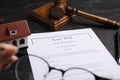 Last will and testament near house model, gavel on black table Royalty Free Stock Photo
