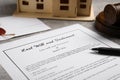 Last will and testament near house model, gavel on light grey table, closeup Royalty Free Stock Photo