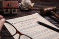 Last will and testament near house model and gavel on wooden table, closeup Royalty Free Stock Photo