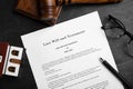 Last will and testament near house model, glasses, gavel on black table, flat lay Royalty Free Stock Photo