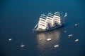 A large sailboat, bark goes into the sea surrounded by many yachts.nThe last windjammer bark Kruzenstern.