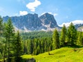 Lastoni de Formin, aka Ponta Lastoi de Formin. Giant mountain block with green meadow, trees and summer sky, Dolomites