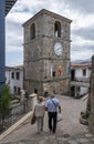 An elderly couple walking hand in hand through the narrow cobblestone streets of the fishing village of Lastres in Asturias Spain Royalty Free Stock Photo