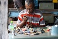 Laminated frame craftsman of small Buddha image used as amulet, working on the table.