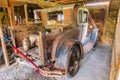 Rusted vintage Ford Model A pickup truck in a barn