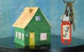 Latchkey with key fob and blurred home in the back,buying house,real estate concept.Selective focus,free copy space Royalty Free Stock Photo