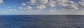 Late afternoon HDR panorama photo of sea spanning all the way to the horizon and blue cloudy sky