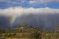 Late afternoon storm with rainbow at leading edge.