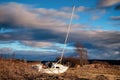 Abandoned sail boat isolated on a grassy coastal plain