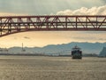 Late afternoon sun shines behind container ship entering harbor Royalty Free Stock Photo