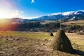 Ate autumn countryside landscape with farming haystacks in highland area of Carpathian Mountains Royalty Free Stock Photo