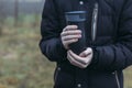 In late autumn, men`s hands are warming themselves on a black toggle switch with a hot drink. Environmentally friendly use of Royalty Free Stock Photo