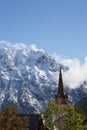 Ancient Stone Church Steeple with Magnificent Snow covered Mountain in the French Alsp Royalty Free Stock Photo