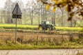 Late autumn. Tractor plows a field near the edge of the forest.